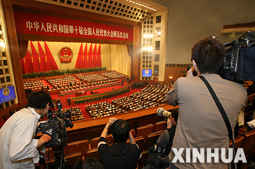  3月13日，十届全国人大五次会议在北京人民大会堂举行第四次全体会议。这是记者在现场采访。